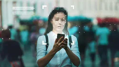 Woman holding a phone with face digitally blurred