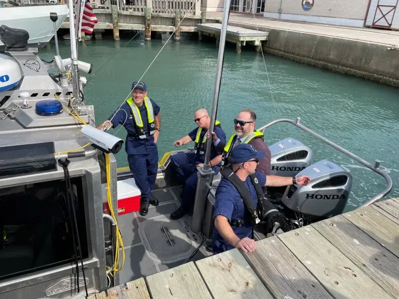 S&T’s Maritime Safety and Security Program Manager Matt Barger (second from right) joins three U.S. Coast Guard (USCG) colleagues at a March 2023 site visit to South Padre Island, TX in a boat on the water.