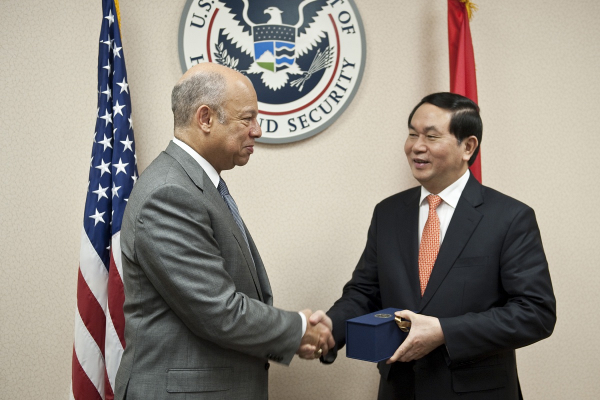 Secretary Johnson, Minister Tran Dai Quang shake hands in front of DHS seal
