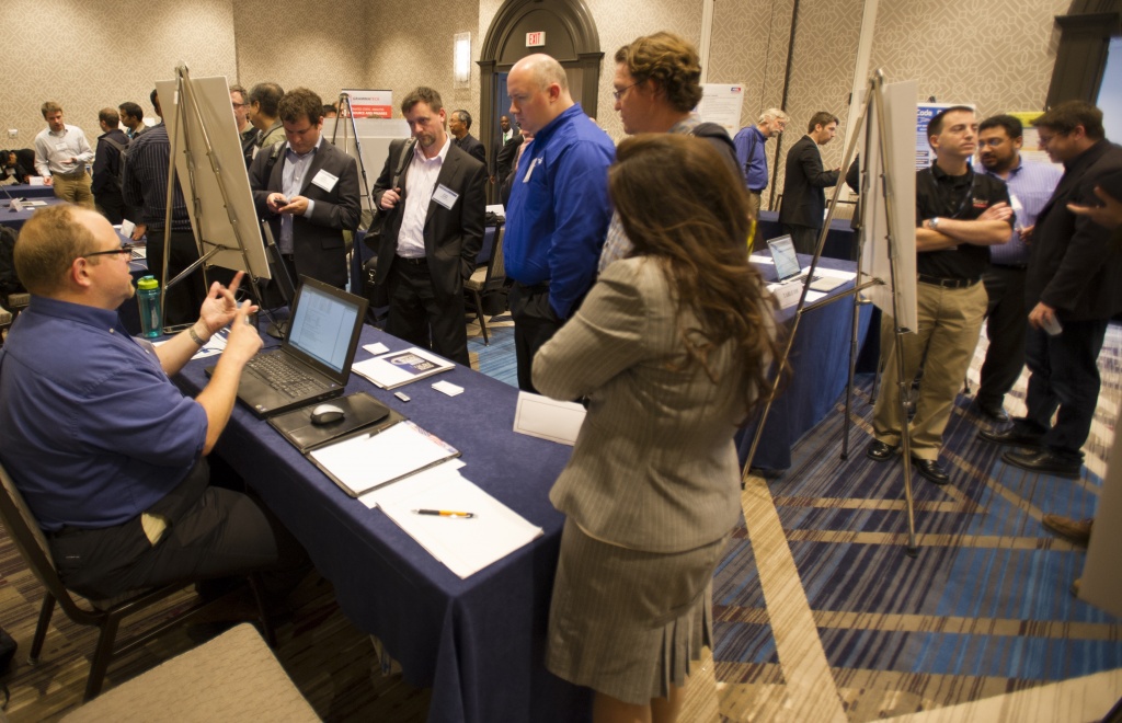 "People gather around vendors to see and discuss new technologies."