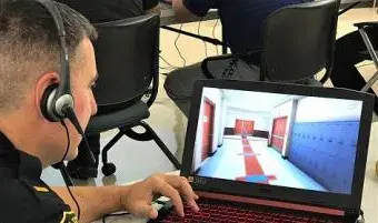 Man with headphones looking at training video on laptop