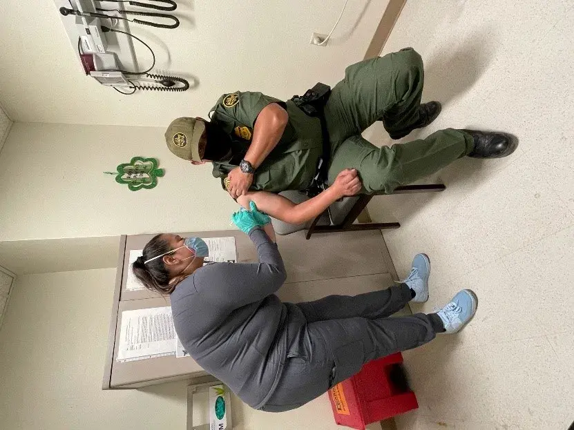 Agent Roberto Gonzalez (right), Ysleta Station, El Paso Sector, receiving a COVID-19 vaccination at the El Paso VA Medical Center