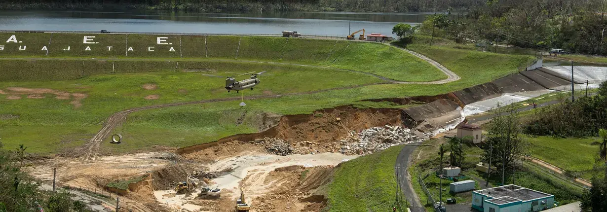  A helicopter of the U.S. Army Corps of Engineers brings sandbags full of crushed rock to stabilize the damaged spillway of the Guajataca Dam, Puerto Rico after Hurricane Maria.