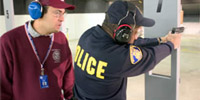 Instructor observing student shooting a pistol