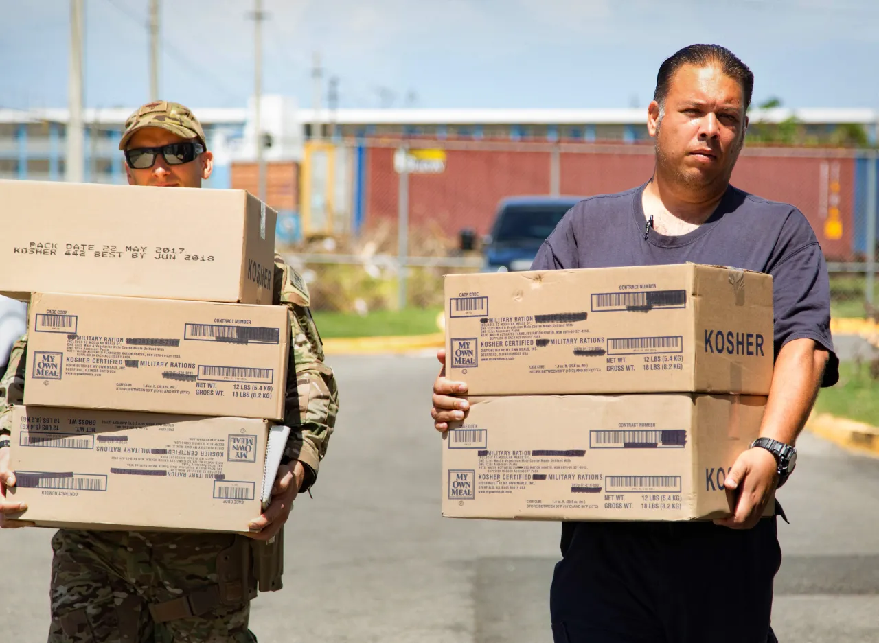 Image: A U.S. CBP agent from the Rio Grande Sector and a local resident delivers supplies to residents of Caban, Puerto Rico