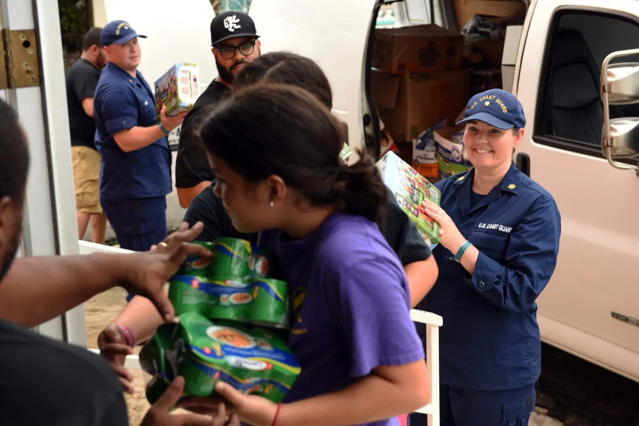 Image: U.S. Coast Guard, local missionaries form a human chain to deliver goods to Loiza, Puerto Rico residents