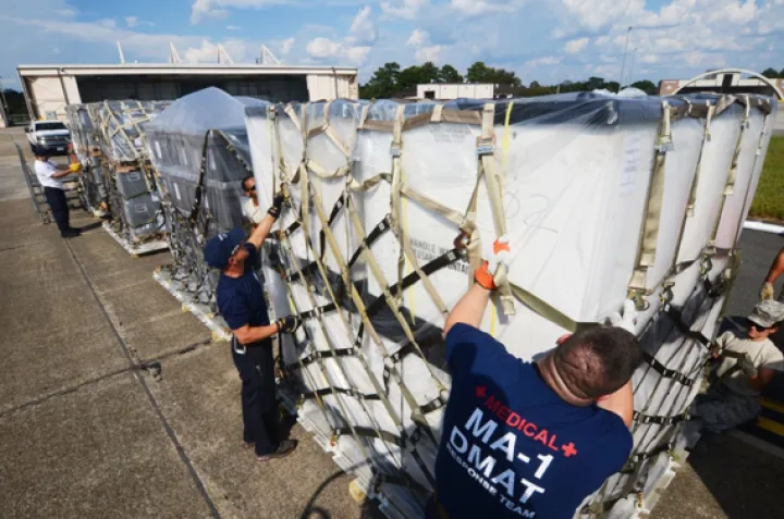 Image: Disaster Medical Assistance Team members secure a cargo net around a pallet of medical supplies on the flight line at Dobbins Air Reserve Base, Ga. Sept. 21, 2017.