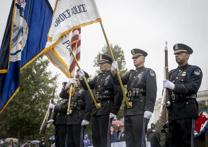 Image: DHS Officers Hold Flags and Guns at the National Police Officers' Memorial Service