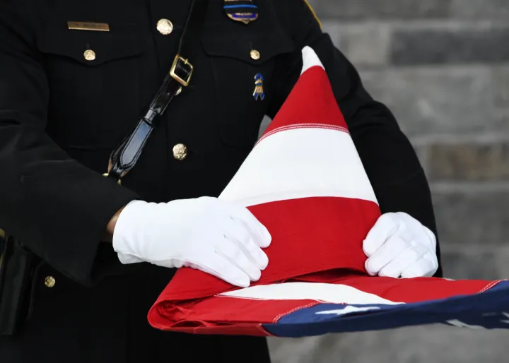 Image: Federal Service Protection (FPS) Officer Folding a Triangle Folded American Flag