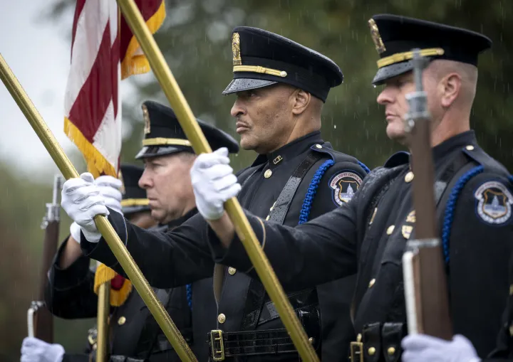 Image: DHS Officers Hold Flags in the Rain