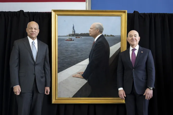 Image: Secretary Mayorkas and former Secretary Johnson pose next to former Secretary Johnson's portrait