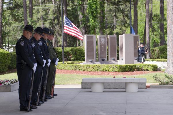 Law enforcement officers honoring those who lost their lives in the line of duty at the FLETC Graduates Memorial.