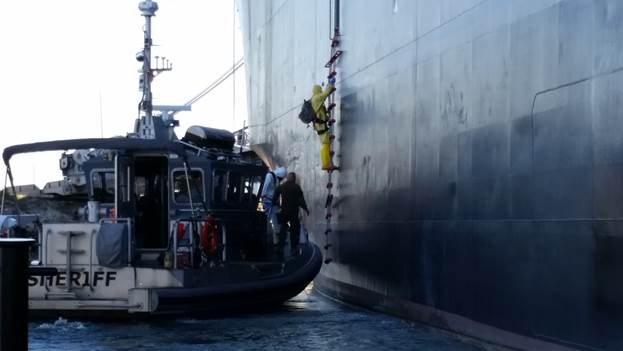 Members of the task force boarding the SS Cape Isabel to collect simulated nuclear detonation debris samples for nuclear forensic analysis. (Photo courtesy of the Federal Bureau of Investigations)
