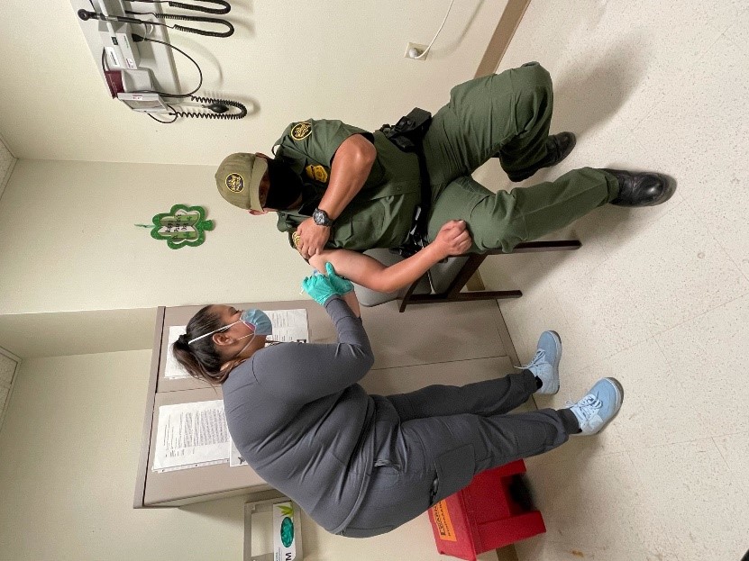 Agent Roberto Gonzalez (right), Ysleta Station, El Paso Sector, receiving a COVID-19 vaccination at the El Paso VA Medical Center