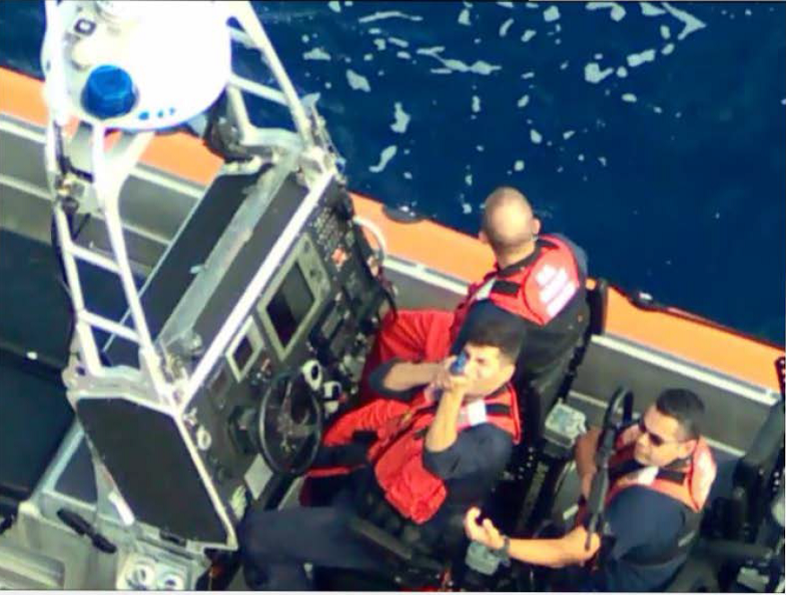 A Coast Guard boat with people carrying simulated weapons.