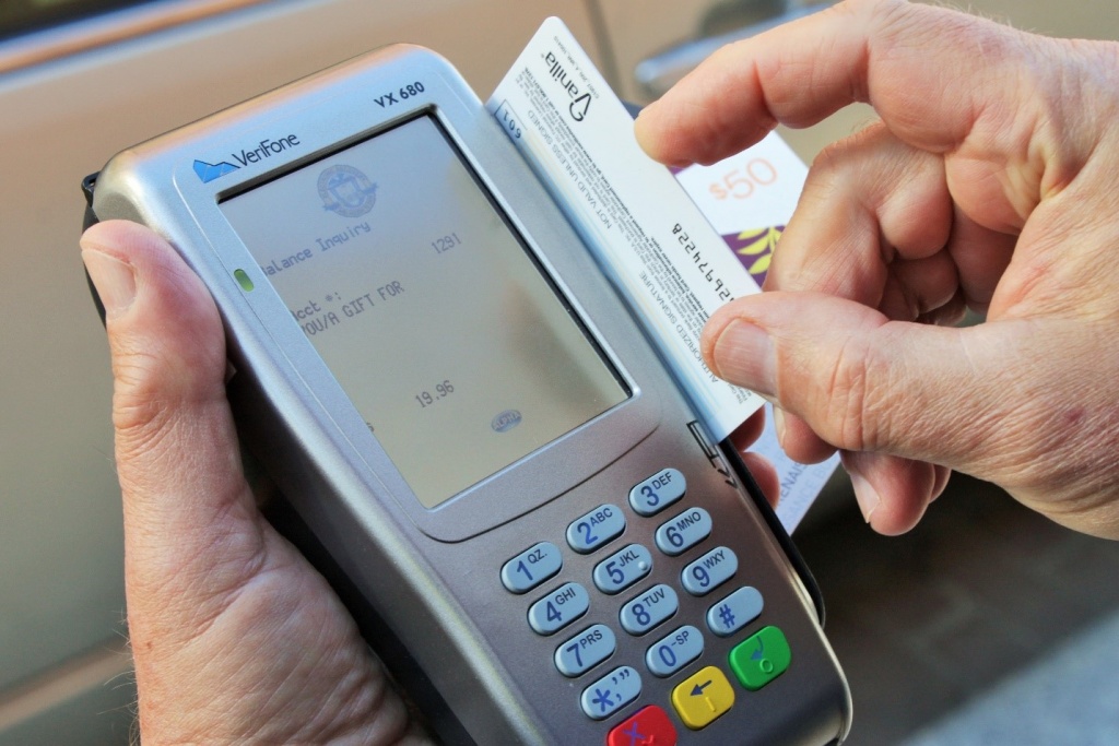 Electronic Recovery and Access to Data (ERAD) Prepaid Card Reader. Someone's hands shown swiping a prepaid card through the ERAD.