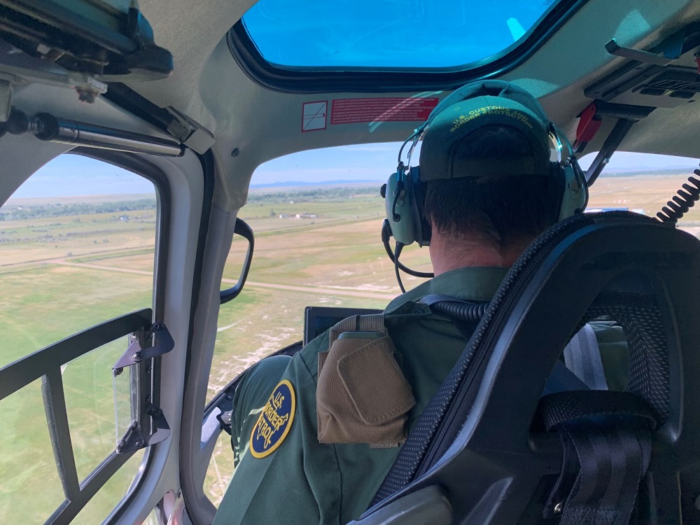 The SATCOM device was tested inside a CBP/AMO helicopter flying along the northern border in Montana. The device is in the brown pouch strapped to the agent's left shoulder.