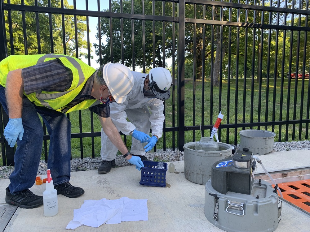 A representative of the Metropolitan Sewer District (MSD), Louisville, KY, helps a University of Louisville researcher take sewage samples. Photo by MSD.