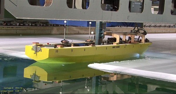 A prototype polar ice breaker moves through ice and water.