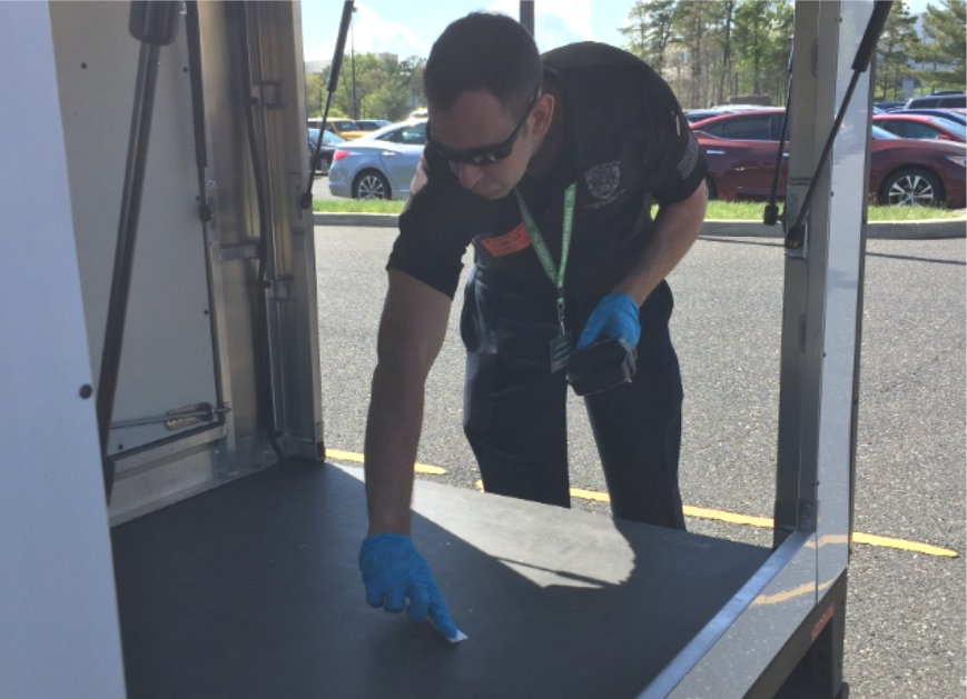 A law enforcement officer uses a handheld ETD to collect samples during the vehicle screening scenario.