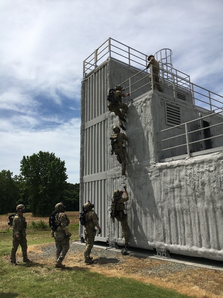 A group of MSRT operators wearing gas masks and PAPRs climb a ship-like structure at MSRT East in Chesapeake, Virginia. Photo by Don Bansleben, S&T.
