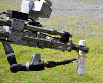 The Wolverine 6X6 robot uses both of its hands to disarm a fake pipe bomb during a demonstration in 2019.