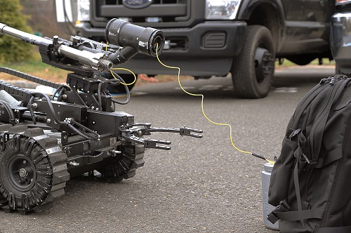 Bomb robot feeds out shock tube detonator REDOP
