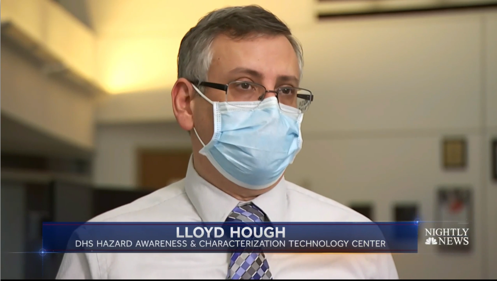 : Dr. Lloyd Hough speaks on camera, wearing a face mask, about the DHS Hazard Awareness & Characterization Technology Center during NBC News interview