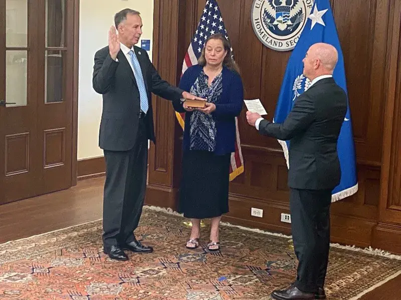 Dr. Dimitri Kusnezov is sworn in alongside his wife, Jacqueline, by DHS Secretary Alejandro Mayorkas. 