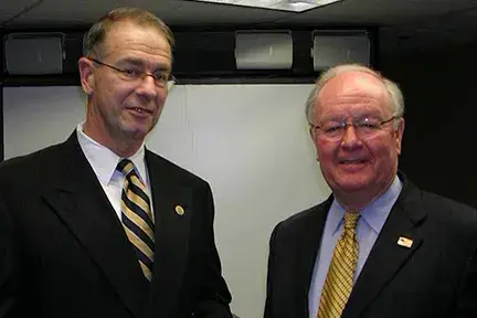 Dr. Kirk Evans, Director of HSARPA, with Dr. McQueary standing in a room.