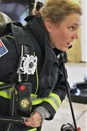 A female first responder in full gear.