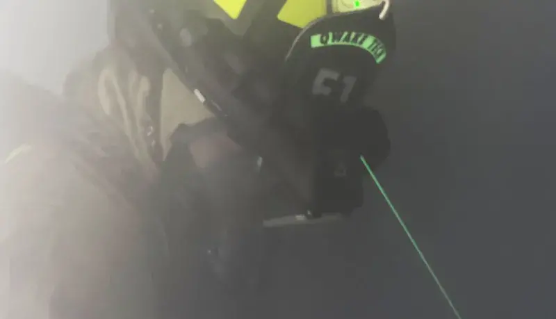 A firefighter using C-THRU Navigator in a smoke-filled space during an operational field assessment.