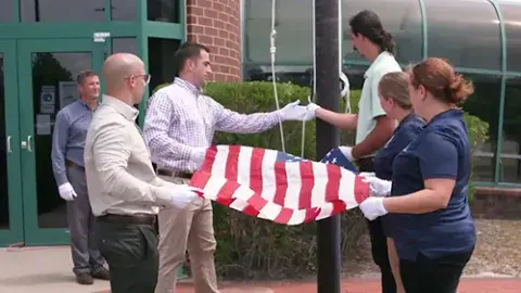 TSL staff putting up the 9/11 commemorative flag
