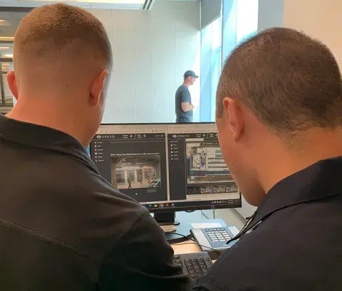 A technology developer from ZeroEyes trains a law enforcement officer on how to verify a gun detection alert from their DeepZero Platform.