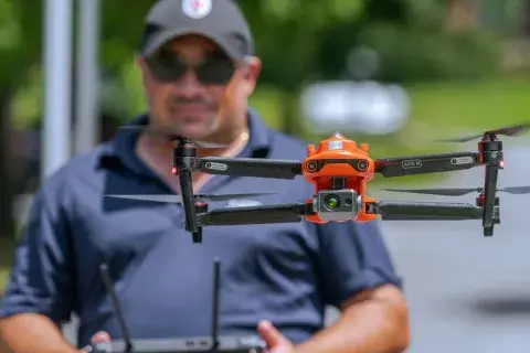 Close up of drone in flight with Federal Aviation Administration Safety Representative pilot Dave Krause  out of focus in the background. 