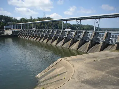 Water is contained by an old spillway structure on the right as part of a dam.  