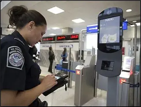 A female U.S. Border patrol agent standing in front of the scanner.