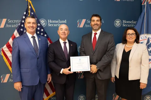 Left to right: Transportation Security Administration (TSA) Administrator David Pekoske, DHS Secretary Alejandro Mayorkas, Team Excellence Award recipient David Cooper, and TSA Senior Official Performing the Duties of the Deputy Administrator Stacey Fitzmaurice.