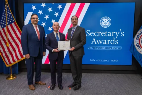 Left to Right: CISA Deputy Director Nitin Natarajan, DHS Secretary Alejandro Mayorkas, and Team Excellence Award recipient, Daniel Stein.
