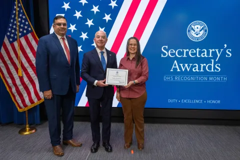 Left to Right: CISA Deputy Director Nitin Natarajan, DHS Secretary Alejandro Mayorkas, and Team Excellence Award recipient, Sheryl Ann Galchutt.