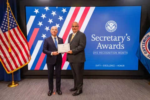 DHS Secretary Alejandro Mayorkas with Team Excellence Award recipient, Wayne A. Dumais.