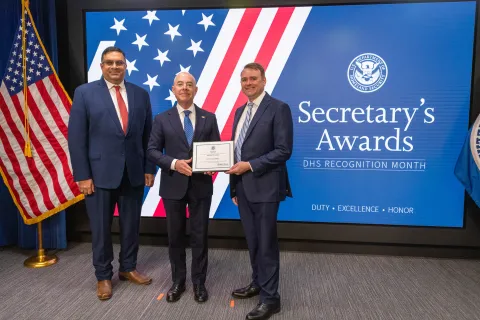 Left to Right: CISA Deputy Director Nitin Natarajan, DHS Secretary Alejandro Mayorkas, and  Innovation Award recipient, Scott McConnell.