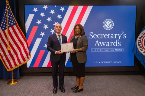 DHS Secretary Alejandro Mayorkas with Team Excellence Award recipient,  Keisha Monroe.