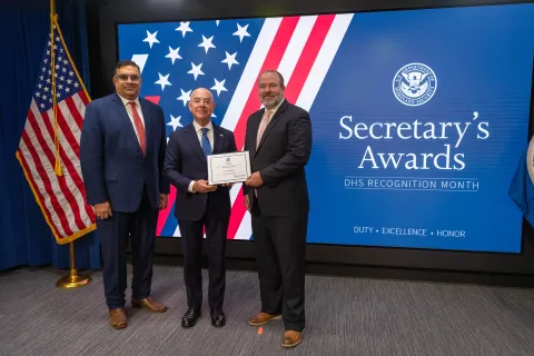 Left to Right: CISA Deputy Director Nitin Natarajan, DHS Secretary Alejandro Mayorkas, and  Innovation Award recipient, Aaron Adams.