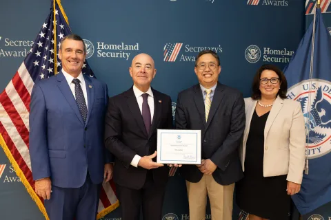 Left to right: Transportation Security Administration (TSA) Administrator David Pekoske, DHS Secretary Alejandro Mayorkas, Team Excellence Award recipient Tri Hoang, and TSA Senior Official Performing the Duties of the Deputy Administrator Stacey Fitzmaurice.
