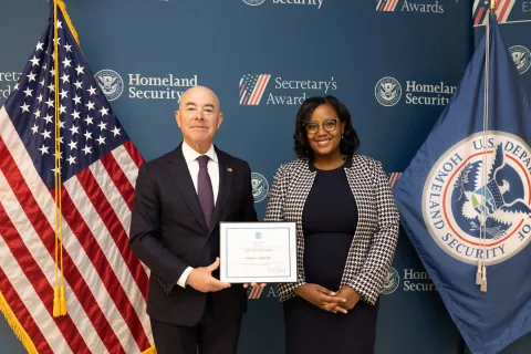DHS Secretary Alejandro Mayorkas with Team Excellence Award recipient, Karine A. Noncent.