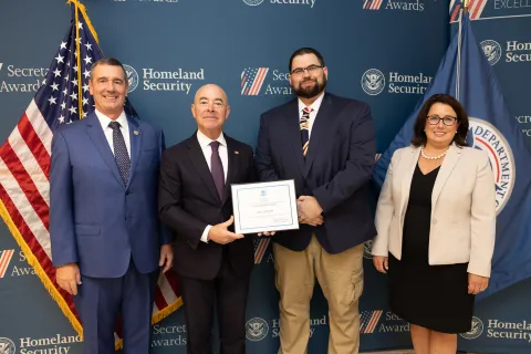 Left to right: Transportation Security Administration (TSA) Administrator David Pekoske, DHS Secretary Alejandro Mayorkas, Team Excellence Award recipient Paul Evenson, and TSA Senior Official Performing the Duties of the Deputy Administrator Stacey Fitzmaurice.