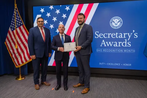 Left to Right: CISA Deputy Director Nitin Natarajan, DHS Secretary Alejandro Mayorkas, and  Innovation Award recipient, Geoffrey Hale.