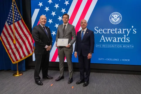 Left to Right: ICE Senior Official Performing Dutes of the Deputy Director Patrick J. Lechleitner, Innovation Award recipient, Patrick G. F. Wilhelm, and DHS Secretary Alejandro Mayorkas.
