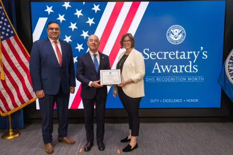 Left to Right: CISA Deputy Director Nitin Natarajan, DHS Secretary Alejandro Mayorkas, and  Innovation Award recipient, Allison Snell.
